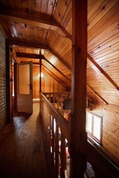 Hütte mit schräger Holzdecke, Boden mit Holzdekor und offenen Türen.