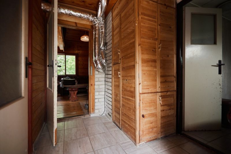 Innenraum einer Hütte mit Holzdekor und Lüftungsrohren bei den Schränken.