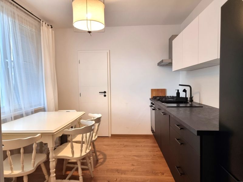 Küche in einer 2-Zimmer-Wohnung mit Essecke und Boden in Holzoptik.