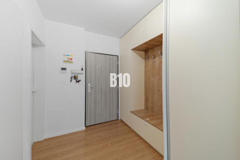 Eingangsbereich mit hellen Möbeln und einem Boden in Holzoptik in einer 4-Zimmer-Wohnung.
