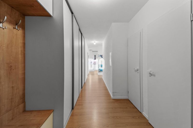 Flur in einer 4-Zimmer-Wohnung mit Holzboden und Stauraum.