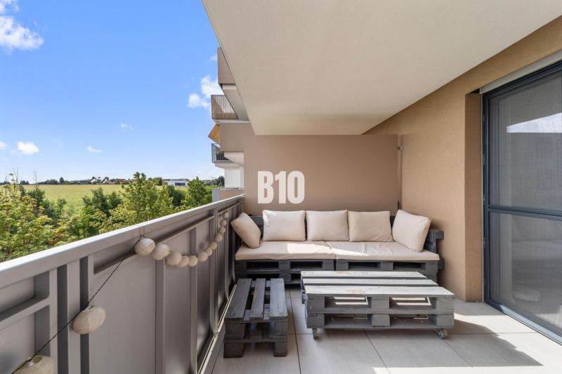 Ein Balkon in einer 4-Zimmer-Wohnung mit Blick auf die Umgebung von Nitra und einer Sitzgelegenheit aus Palettenholz.