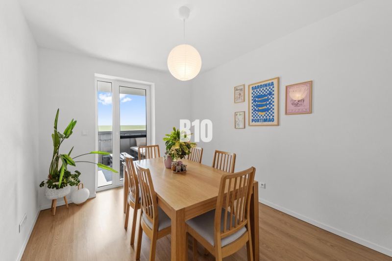 Esszimmer in einer 4-Zimmer-Wohnung mit Holzboden und Wanddekorationen.