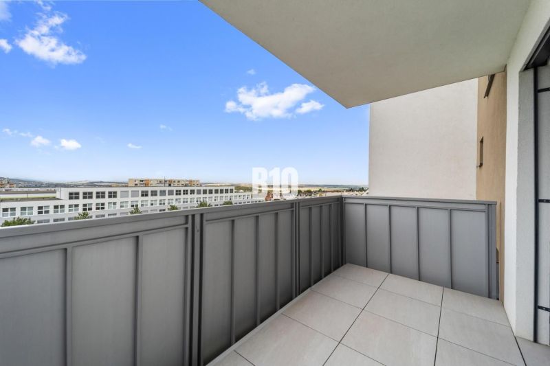Der Balkon einer 4-Zimmer-Wohnung in Nitra mit Blick auf moderne Bebauung.