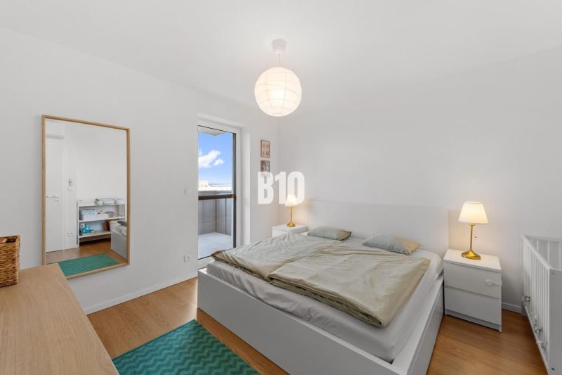 Helles Schlafzimmer mit Holzboden und Zugang zum Balkon in einer 4-Zimmer-Wohnung.