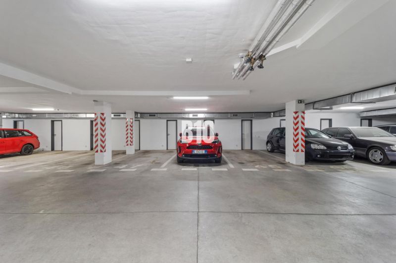 Unterirdische Garage mit geparkten Autos in einer 4-Zimmer-Wohnung in Nitra, Betonboden.