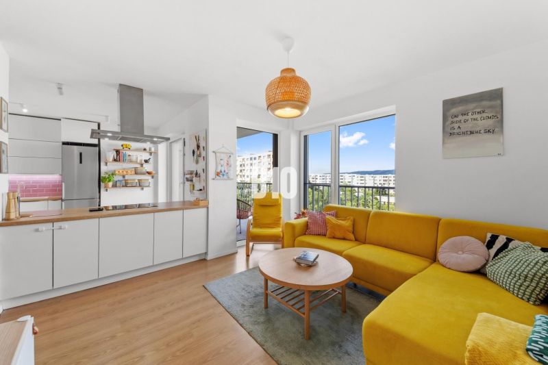 Wohnzimmer einer 4-Zimmer-Wohnung mit Holzboden und gelbem Sofa.