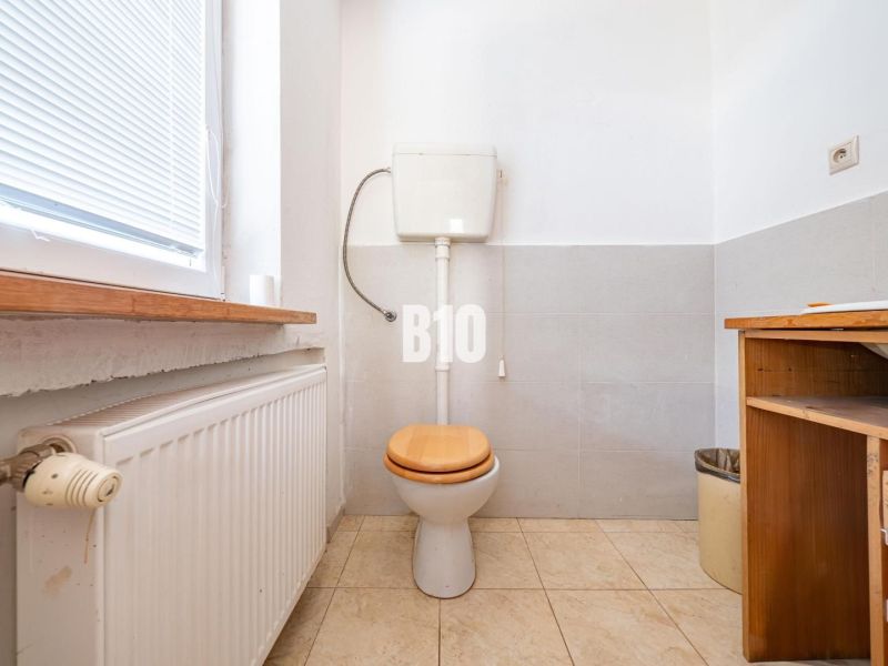 Toilette mit Fenster, Heizkörper und Stauraum in einem Einfamilienhaus.