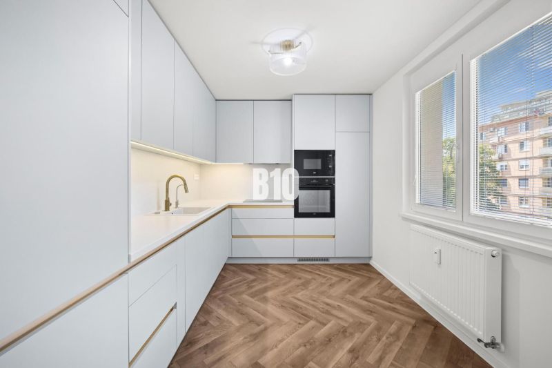 Eine Küche mit moderner Ausstattung und einem Boden in Holzoptik in einer 3-Zimmer-Wohnung.