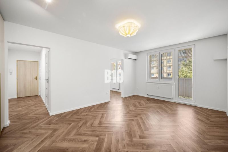 Wohnzimmer in einer 3-Zimmer-Wohnung mit gemustertem Boden in Holzoptik.