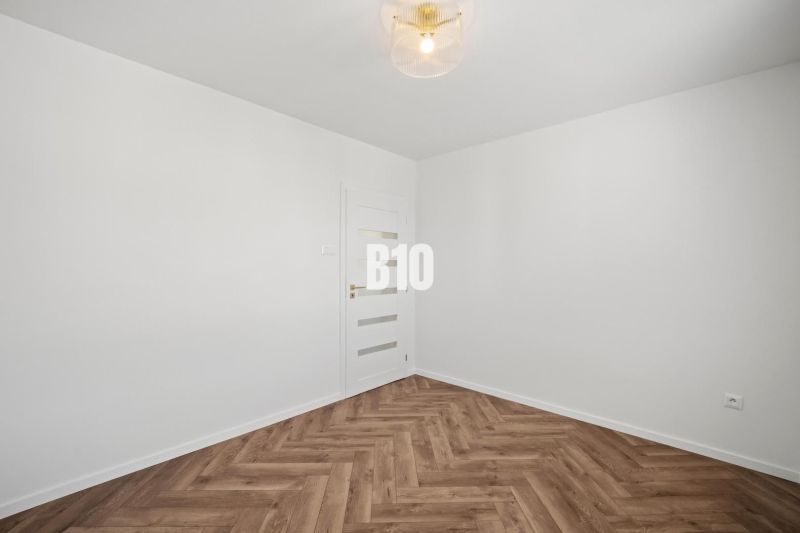 Weiße Wand und Boden mit Holzdekor in einer 3-Zimmer-Wohnung.
