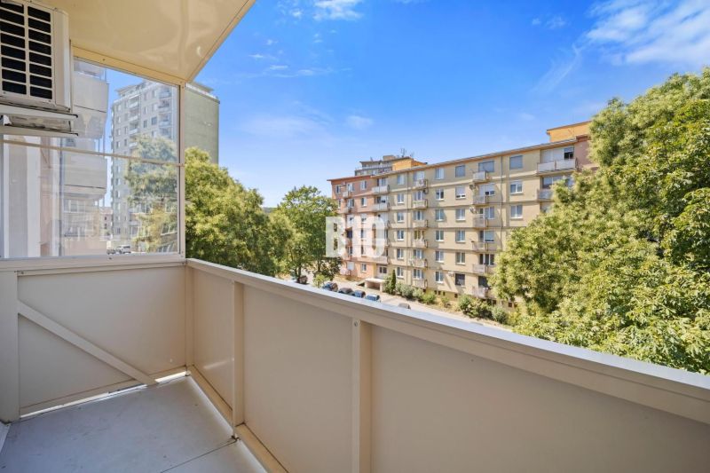Blick vom Balkon einer Dreizimmerwohnung in Nitra auf die Siedlung und die Bäume.