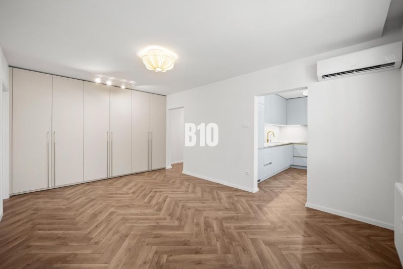 Wohnzimmer in einer 3-Zimmer-Wohnung mit Holzboden und Einbauschrank.