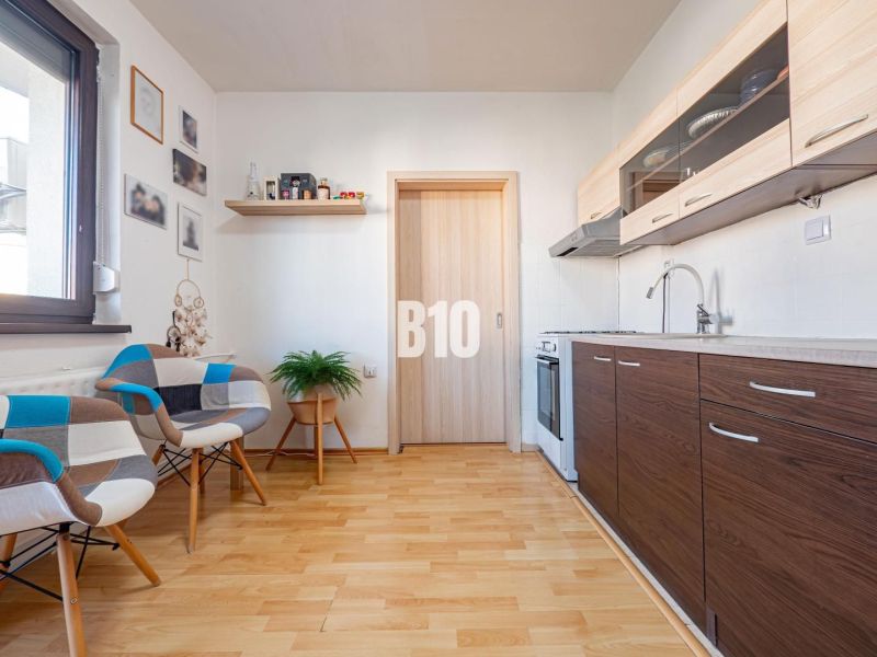Die Küche in der Einzimmerwohnung mit einem Holzboden und modernen Möbeln.