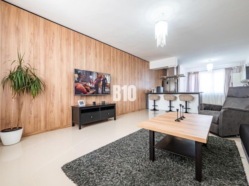 Wohnzimmer mit Teppich, Fernseher und Holzdekor in einem Einfamilienhaus.