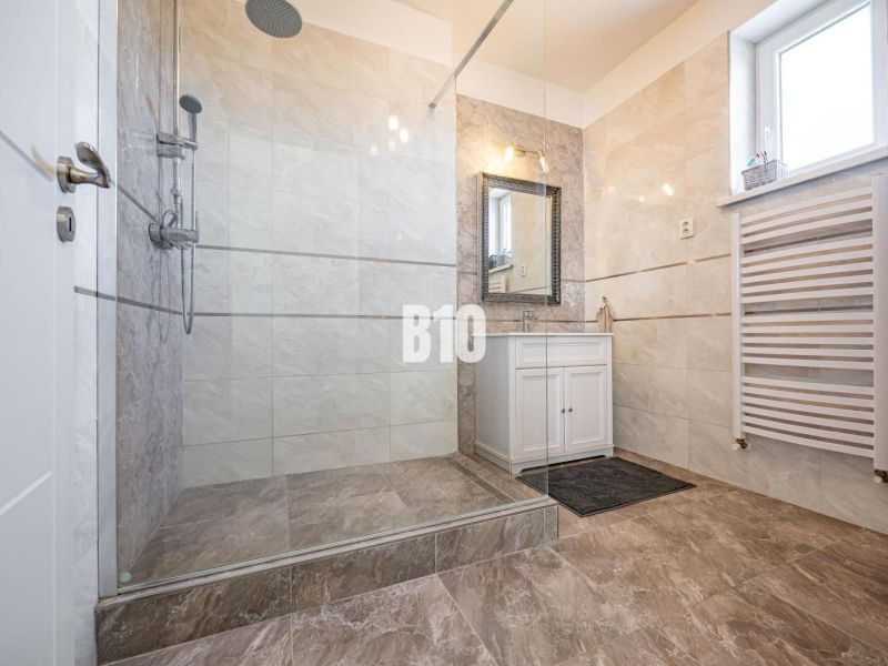 Badezimmer in einem Einfamilienhaus mit geräumiger Dusche und Waschbecken.