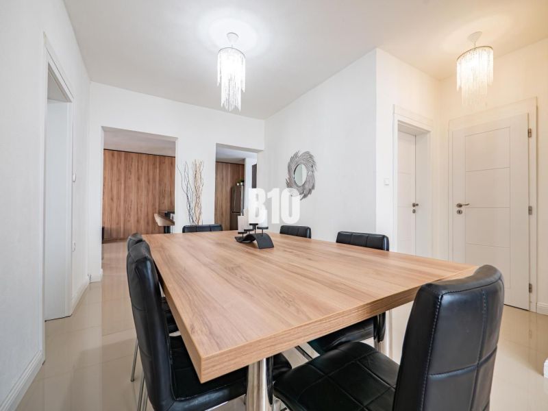 Esszimmer in einem Einfamilienhaus mit großem Tisch und schwarzen Stühlen.