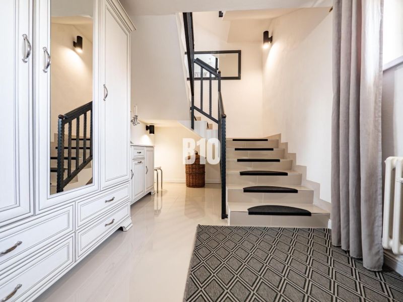 Die Treppe und die weißen Möbel verleihen dem Einfamilienhaus ein Gefühl von Luftigkeit und Stil.