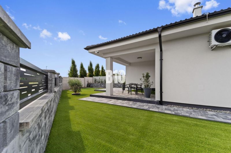 Rasenhof und Terrasse eines Einfamilienhauses in Nitra mit Gartenmöbeln.