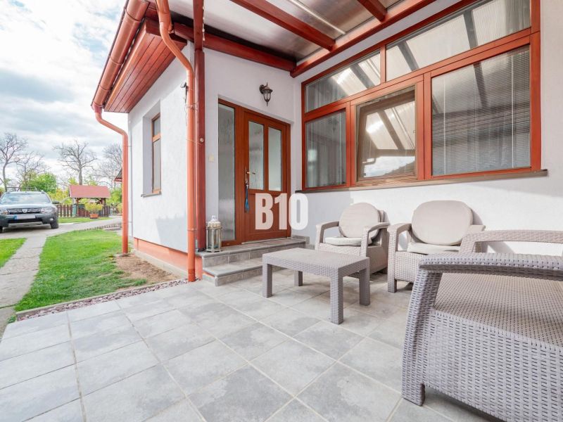 Einfamilienhaus in Nitra mit einem Gartenbereich auf einer gepflasterten Terrasse, Raum für Entspannung.