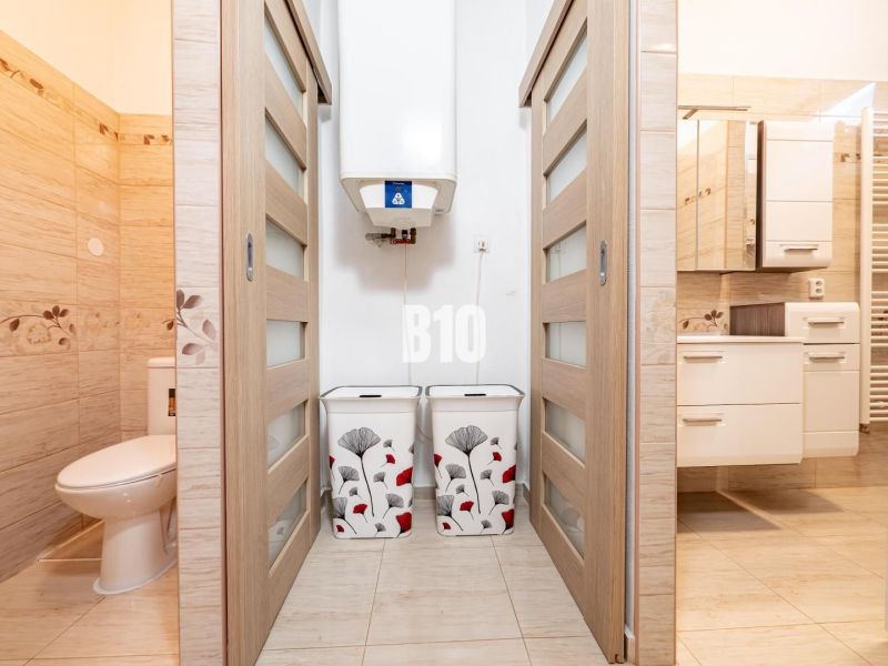 Badezimmer und Toilette im Einfamilienhaus mit Fliesenboden und Schiebetüren.