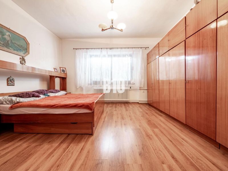 Schlafzimmer in einem Einfamilienhaus mit Bett, Schrank und Boden mit Holzdekor.