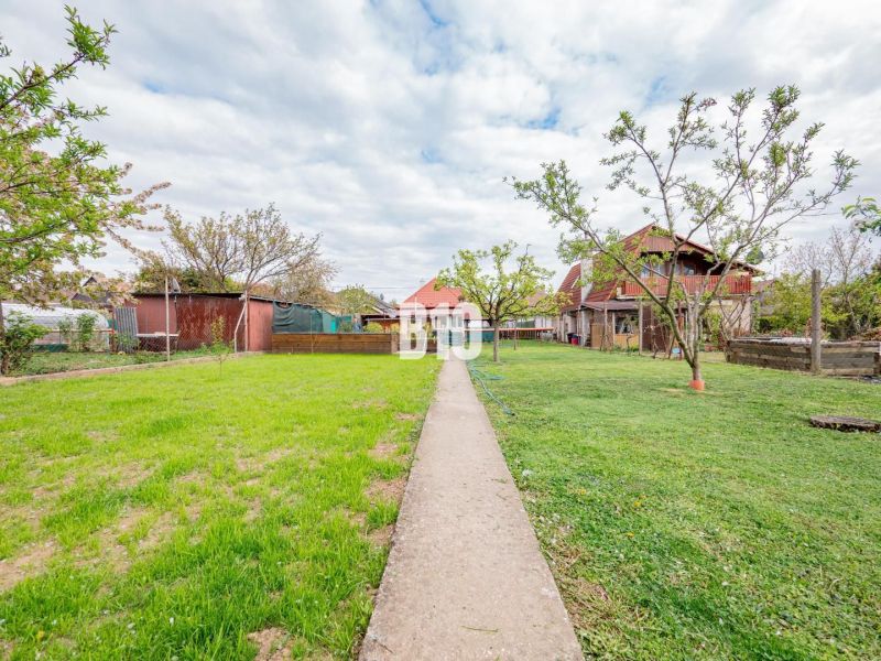 Der Garten des Einfamilienhauses in Nitra mit Rasen und Gehweg.