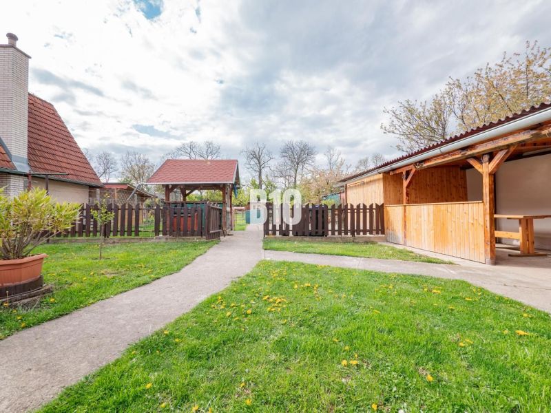 Nitra, Einfamilienhaus, Garten mit Holzpavillon, Gehweg und Umzäunung.