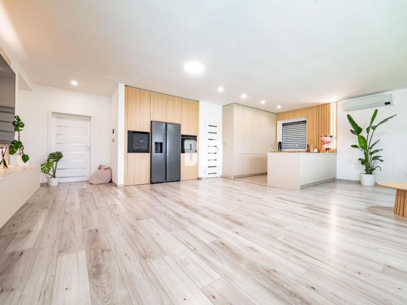 Innenraum eines Einfamilienhauses mit Holzboden und moderner Küche.