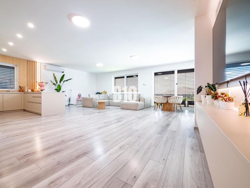 Ein geräumiges Wohnzimmer mit Holzdekorboden und großer Sitzgelegenheit in einem Einfamilienhaus.