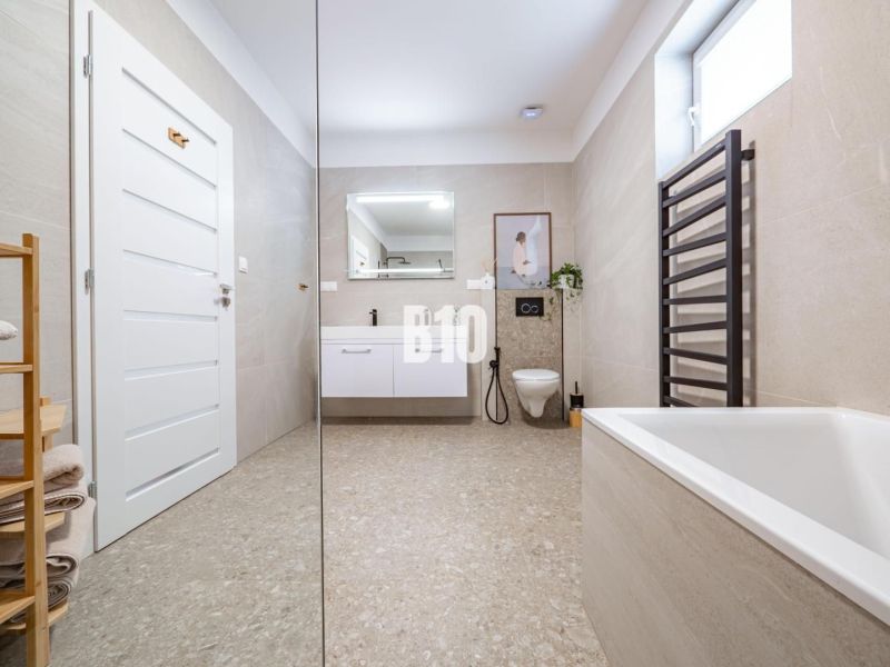 Ein geräumiges Badezimmer in einem Einfamilienhaus mit einer eleganten Badewanne und einem modernen Waschbecken.