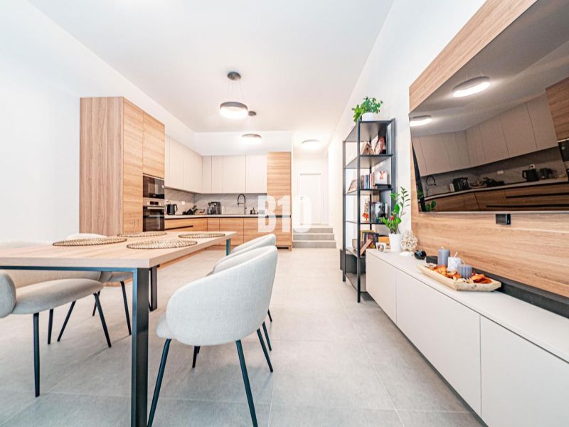 Küche mit Esszimmer in einem Einfamilienhaus, helle Wände, Holzakzente, Esstisch.