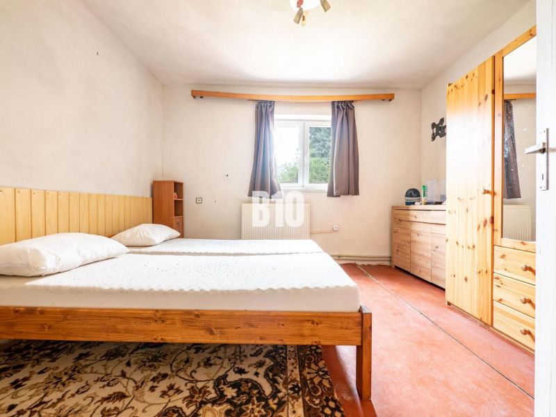 Schlafzimmer im Einfamilienhaus mit Holzmöbeln und Teppich.