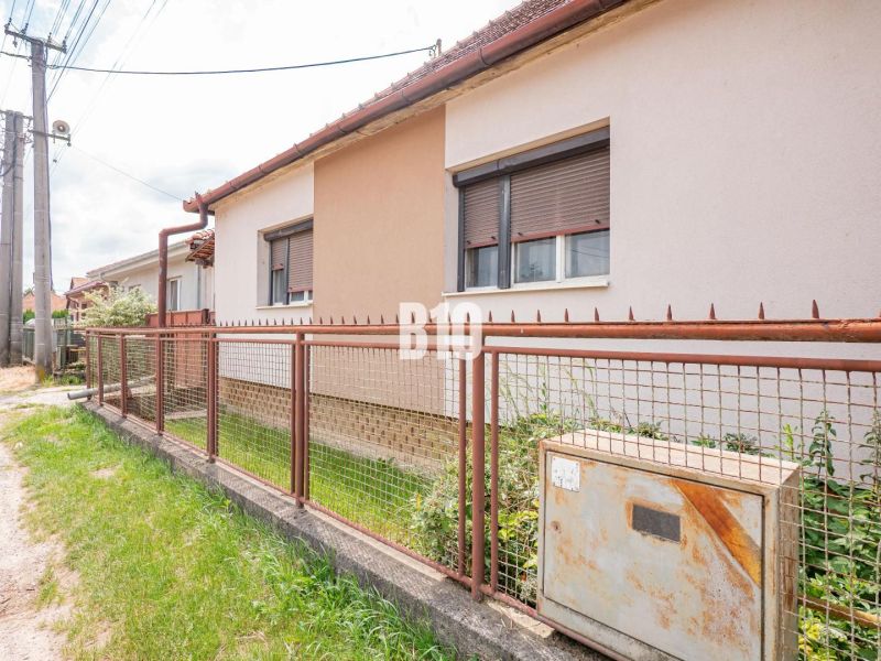 Ein Einfamilienhaus in Nitra mit einem Zaun neben Elektroinstallationen und Vegetation auf dem Grundstück.