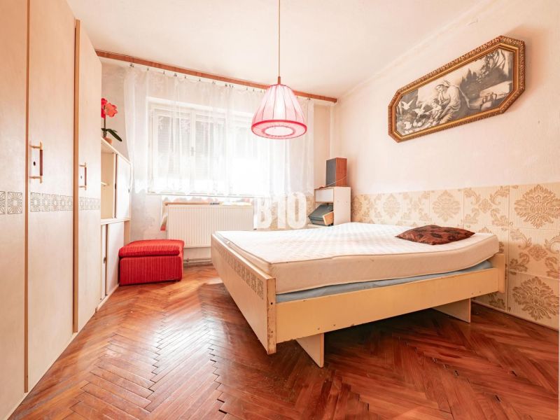 Ein Schlafzimmer in einem Einfamilienhaus mit einem Holzboden und Vintage-Accessoires.