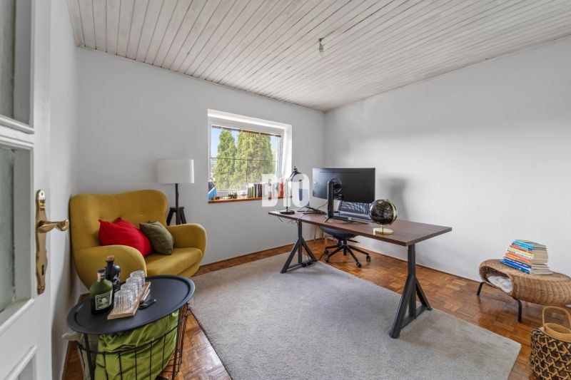 Gelber Sessel, Schreibtisch mit Monitor, Boden mit Holzdekor, Einfamilienhaus.