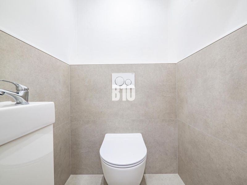Badezimmer in einer 3-Zimmer-Wohnung mit WC und Waschbecken, einfache Fliesen an den Wänden.