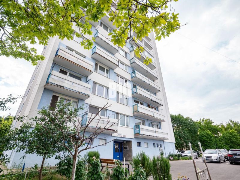 Ein Wohnhaus in Nitra mit Bäumen und einem Parkplatz vor der 3-Zimmer-Wohnung.