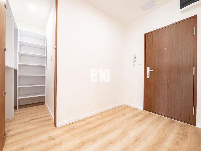 Eingangsflur einer 3-Zimmer-Wohnung mit Holzboden und Einbauschrank.