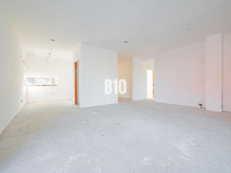 Geräumiges Interieur mit weißen Wänden und Betonboden in einem Einfamilienhaus.