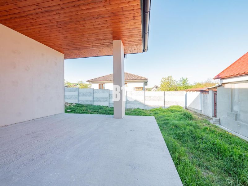 Ein Einfamilienhaus in Nitra mit einer Terrasse und Blick auf den Garten mit einer Rasenfläche.
