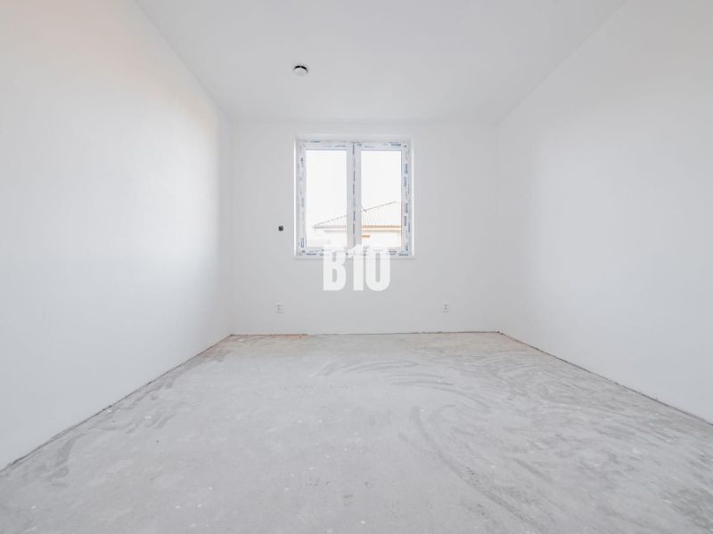 Ein leerer Raum in einem Einfamilienhaus mit Betonboden und Kunststofffenster.