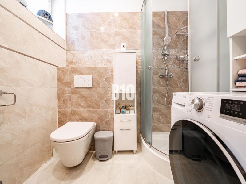 Kúpeľňa v rodinnom dome s práčkou, sprchovacím kútom a toaletou.

Badezimmer in einem Einfamilienhaus mit Waschmaschine, Dusche und Toilette.