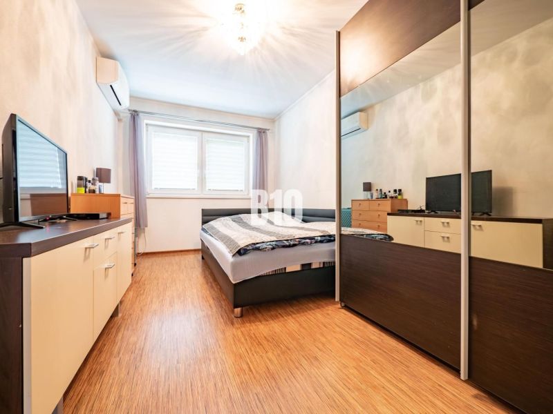 Schlafzimmer in einem Einfamilienhaus mit Holzboden, Schrank und Fernseher.