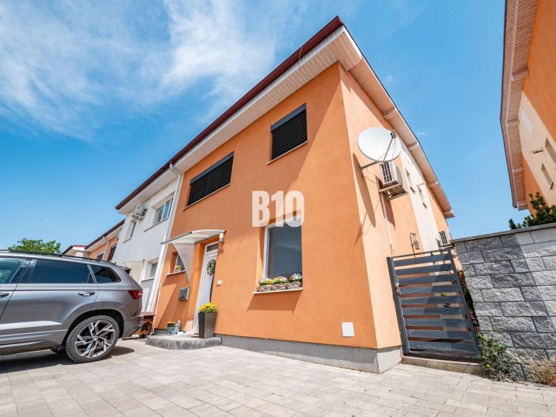 Ein Einfamilienhaus in Nitra mit einer orangefarbenen Fassade und einem Auto im Hof.