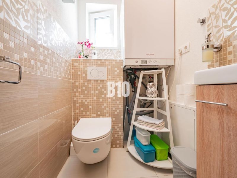 Ein Badezimmer in einem Einfamilienhaus mit Fliesen und moderner Ausstattung.