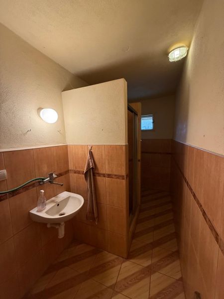 Ein Badezimmer in einem Einfamilienhaus mit einem Boden in Holzoptik und einer Duschkabine.