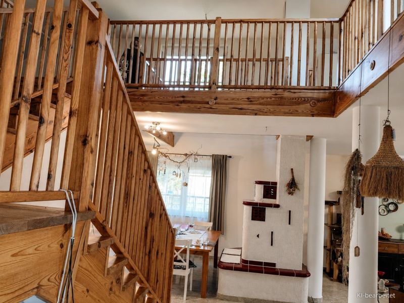 Innenraum eines Einfamilienhauses mit Treppe und Kamin, Boden mit Holzdekor.