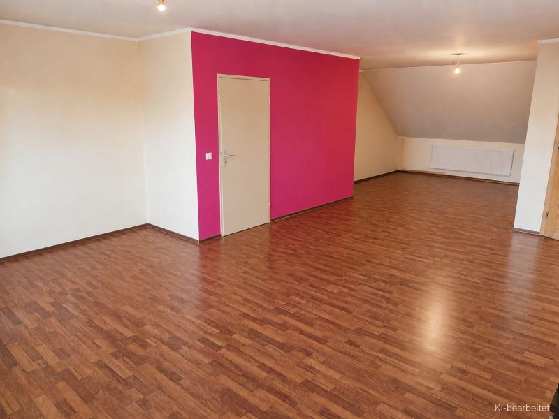 Wohnzimmer in einem Einfamilienhaus mit Holzboden und rosa Wand.