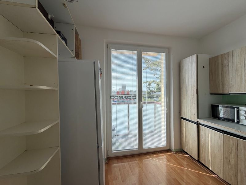 Küche in einer 3-Zimmer-Wohnung mit Holzboden und Einbauschränken.